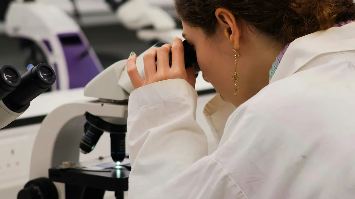 A laboratory researcher looking through a microscope