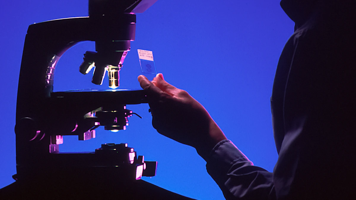 A researcher examines a sample beside a laboratory microscope