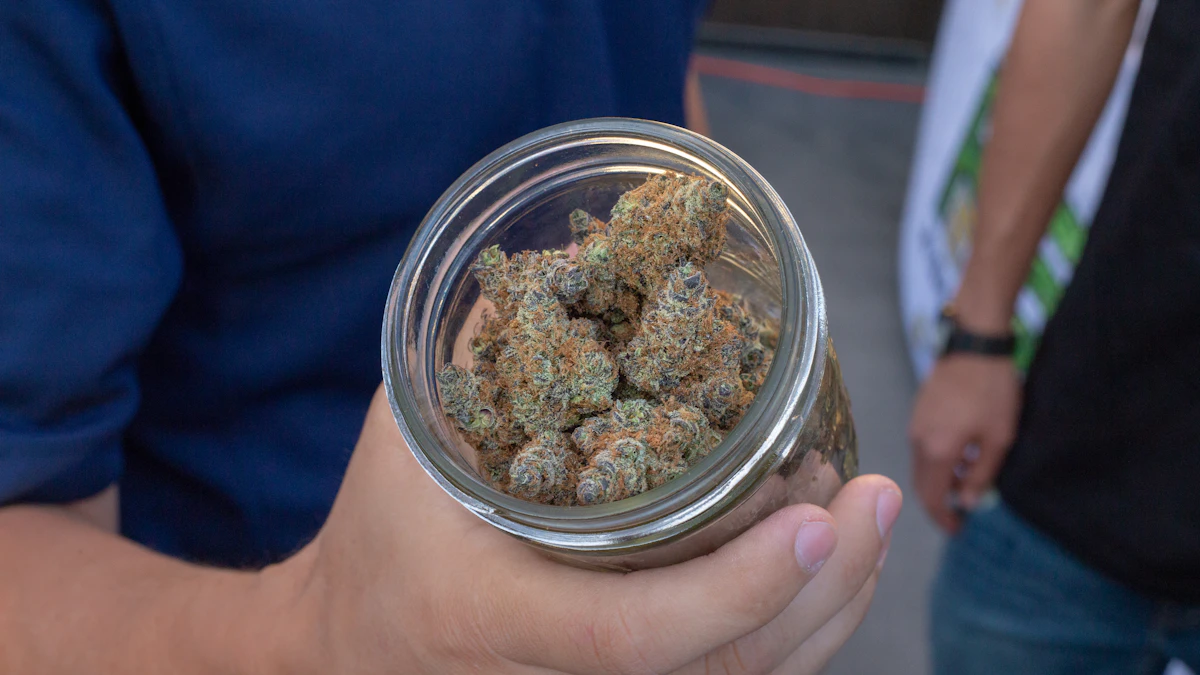 Cannabis flower arranged beside a storage jar
