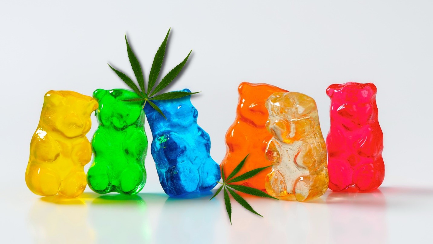 Colorful gummy bears displayed with cannabis leaves